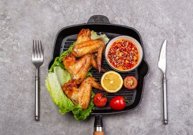 Delicious grilled chicken wings and vegetable salad