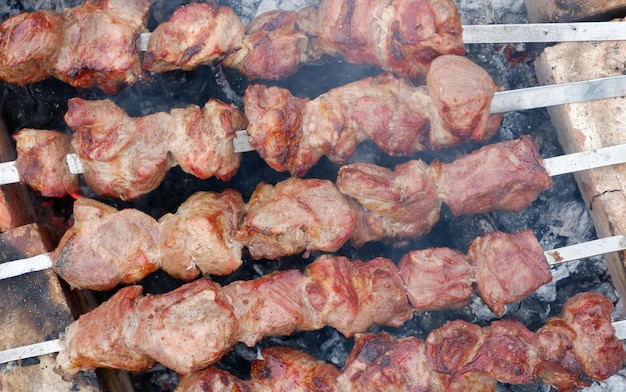 Delicious grilled pork meat in BBQ Barbecue with pork meat Kebabs on the grill CloseUp Of Meat On Barbecue Grill With Smoke