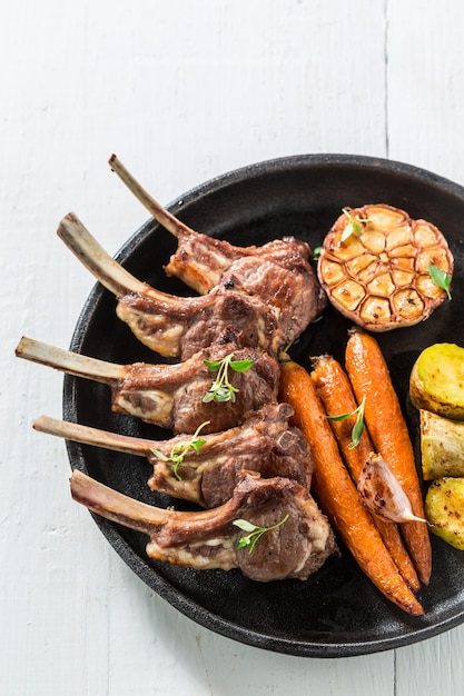 Delicious grilled ribs of lamb on an old white table