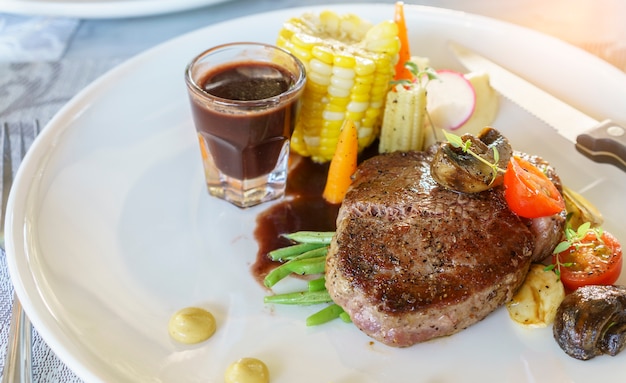 Delicious grilled Wagyu tenderloin steak with red wine sauce and vegetable on white plate