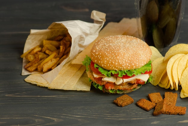 Delicious hamburger with fries snacks and chips Mix of snacks Yummy burger and salty snack including potato chips