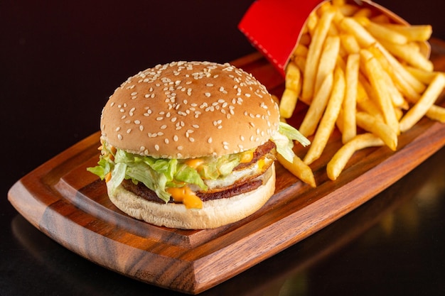 Delicious hamburger with two meats, cheese, fried egg, sauce and salad with french fries.