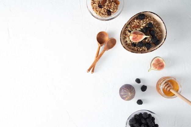 Delicious healthy breakfast of oatmeal granola with figs and honey on a white table top view space for text