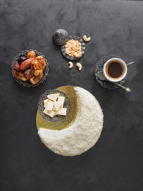 Delicious homemade cake in the shape of a Crescent moon, served with dates and coffee cup