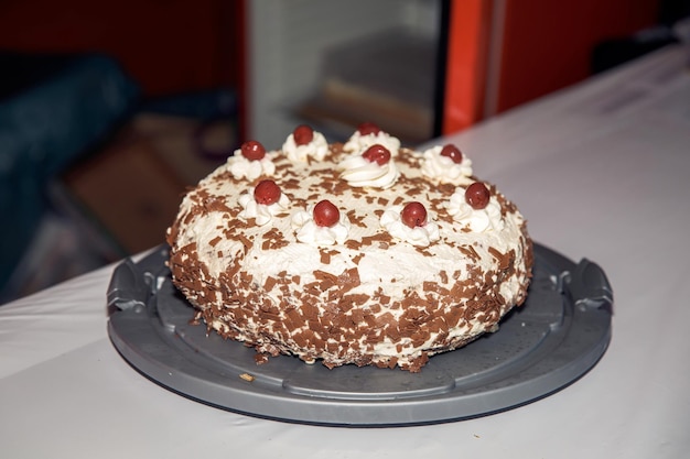 Photo delicious homemade chocolate cake with whipped cream and cherries on top served on a dark plate