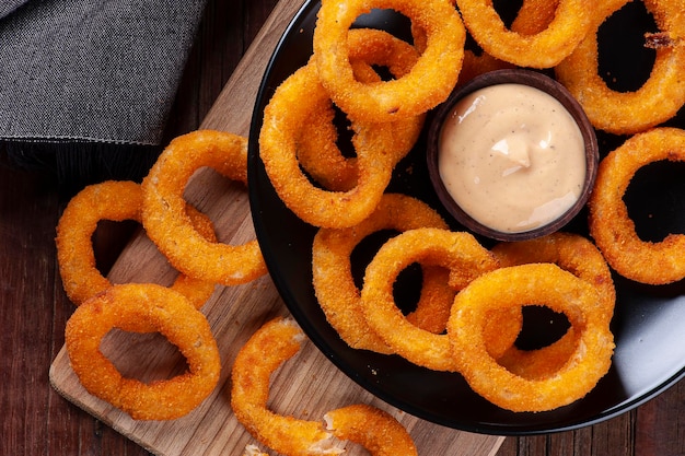 Delicious homemade crunchy fried onion rings with spicy sauce