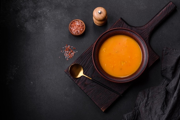 Delicious hot pumpkin and carrot soup puree with spices and herbs