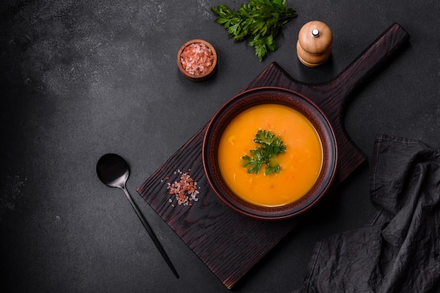 Delicious hot pumpkin and carrot soup puree with spices and herbs