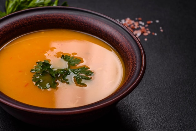 Delicious hot pumpkin and carrot soup puree with spices and herbs