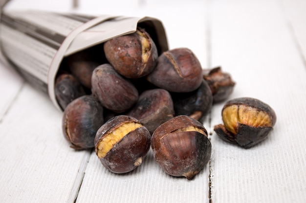 Delicious hot toasted chestnuts wrapped on newspaper.