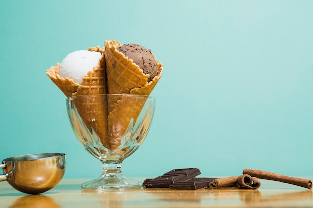 Delicious ice cream cups in bowl and chocolate 