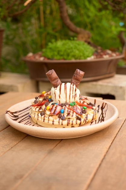 Delicious ice cream waffle with chocolate on wooden table