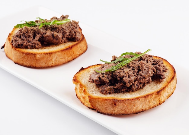 Delicious italian bruschetta with truffle pate on white plate