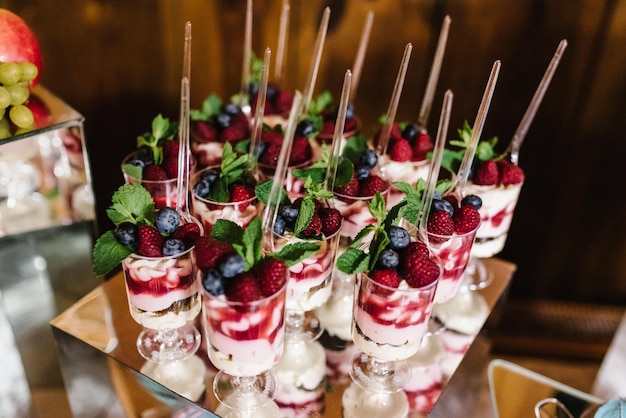 Delicious italian dessert panna cotta with berry sauce fresh berries raspberry blueberry and mint on table