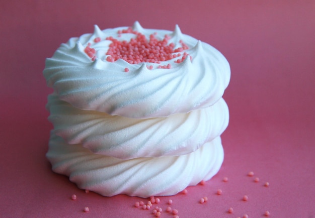 Delicious italian dessert white meringues on a pink background