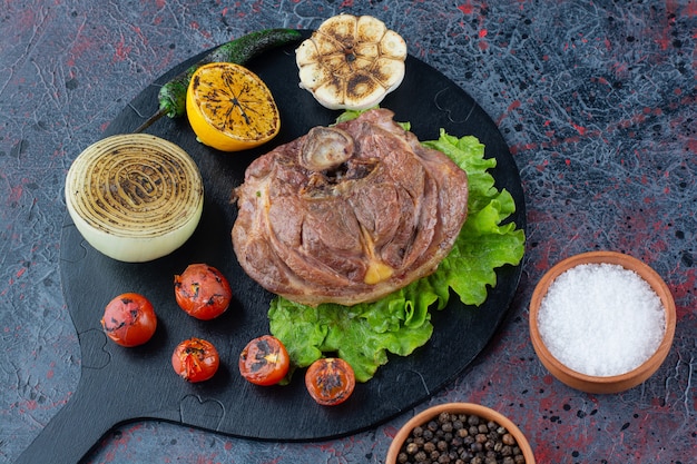 Delicious juicy steak with grilled vegetables on wooden cutting board.