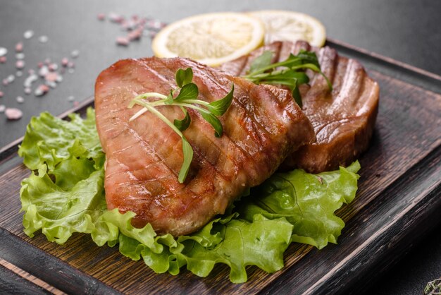 Delicious juicy tuna steak grilled with spices and herbs and lemon slices