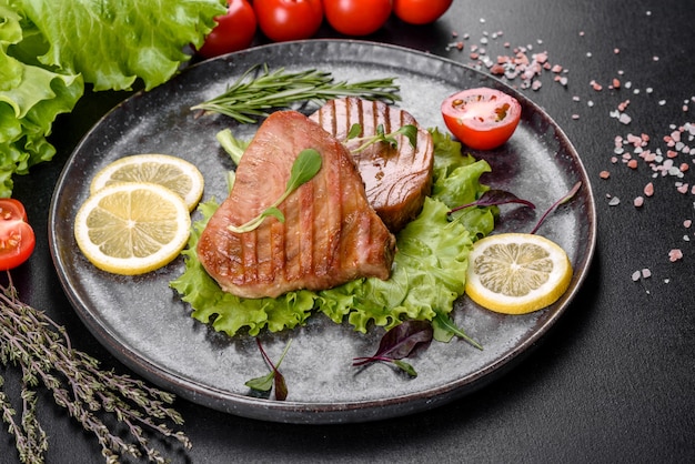 Delicious juicy tuna steak grilled with spices and herbs and lemon slices