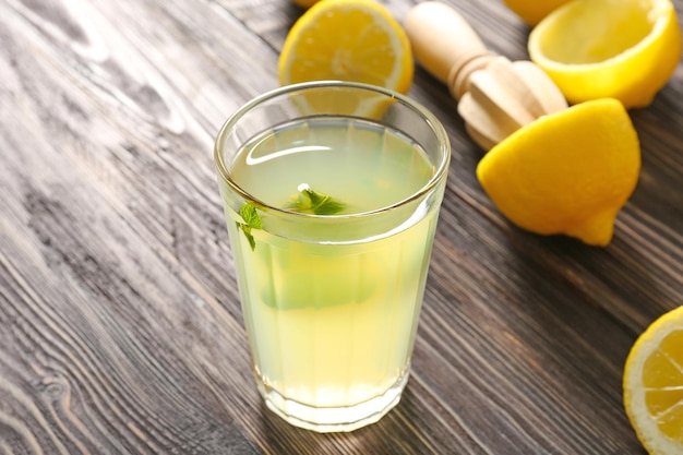 Delicious lemon juice in glass on wooden background