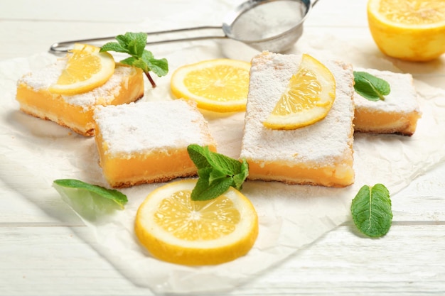 Delicious lemon pie bars on wooden table