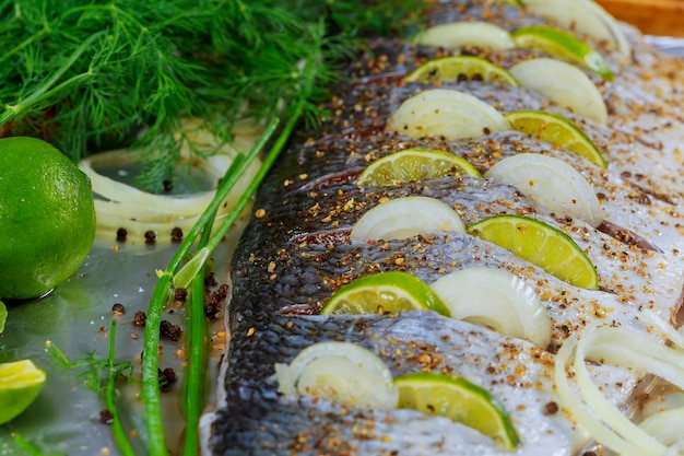 Delicious marinated fish with lemon and onion dish in the oven