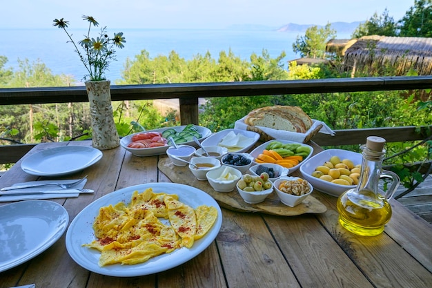 A delicious Mediterranean breakfast of fresh fruit and other nourishing foods served on a table overlooking the sea creating an atmosphere of wellbeing