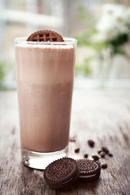 Delicious milk shake cocktail on rustic wooden table close up