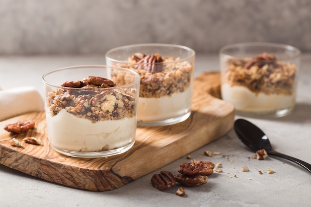 Delicious natural yogurt parfait with caramel, pecan nuts on conctere background