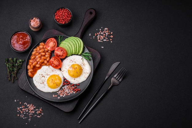 Delicious nutritious English breakfast with fried eggs tomatoes and avocado