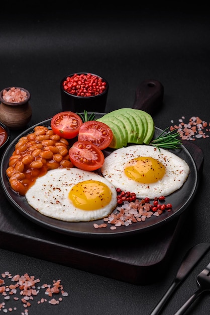 Delicious nutritious English breakfast with fried eggs tomatoes and avocado