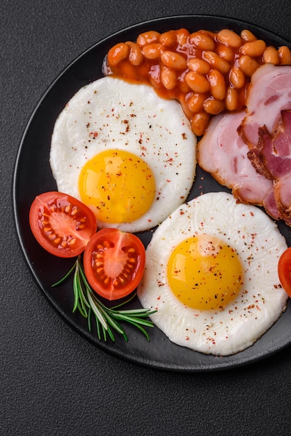 Delicious nutritious English breakfast with fried eggs and tomatoes