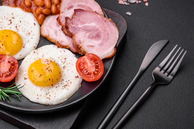 Delicious nutritious English breakfast with fried eggs and tomatoes