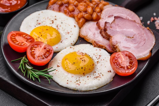 Delicious nutritious English breakfast with fried eggs and tomatoes