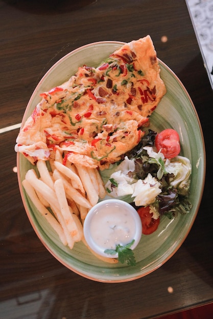 Delicious omlette and breakfast plate on the table.