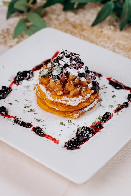 Delicious Pancakes are served with currant jam and apples on a plate ready for eat