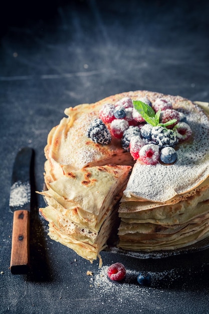 Delicious pancakes cake with berries and powder sugar