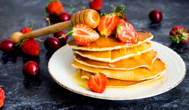 Delicious pancakes with berries and honey