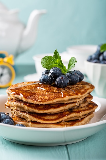 Delicious pancakes with chocolate drops, honey and blueberries. Healthy breakfast concept with copy space