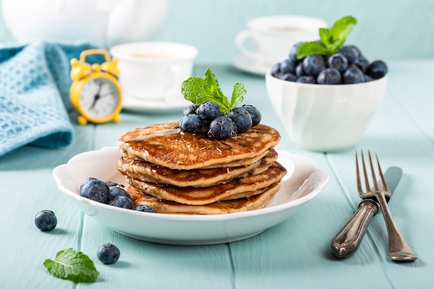 Delicious pancakes with chocolate drops, honey and blueberries. Healthy breakfast concept