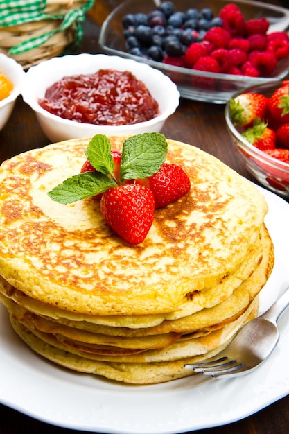 delicious pancakes on wooden table with fruits