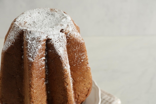 Delicious Pandoro cake decorated with powdered sugar on table closeup and space for text Traditional Italian pastry