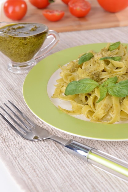 Delicious pasta with pesto on plate on table closeup