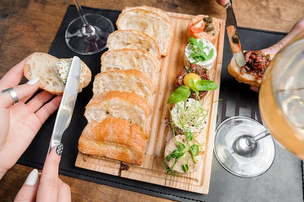 Delicious paste and tartar sauce with slices of white bread served in the wooden plate