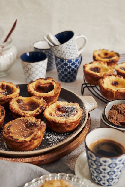 Delicious Pastel de Nata Vanilla pastries with espresso on a white table