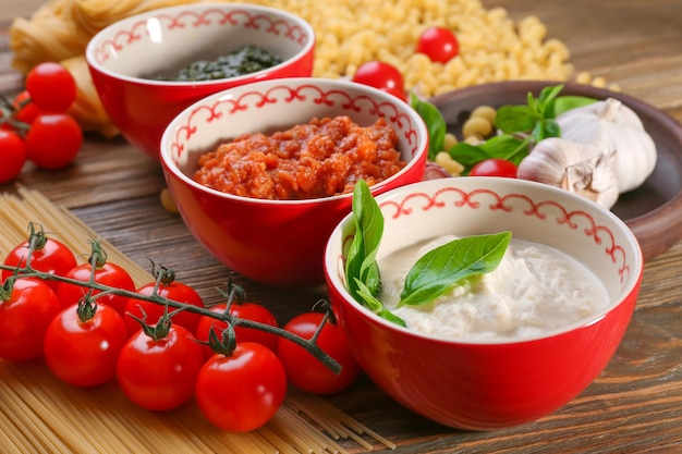 Delicious pesto bolognese and white sauces for pasta in bowls on table