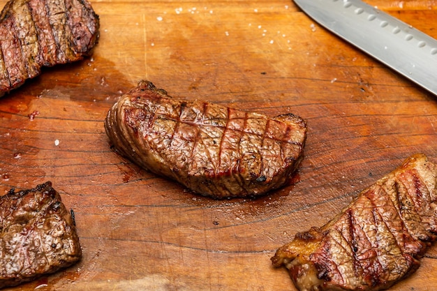 delicious picanha steak over wet cutting board on a barbecue concept scene