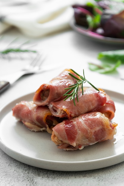 Delicious pigs in blankets, meat wrapped in bacon, homemade cooked meat bites. Bright food photo.