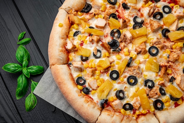 Delicious pizza with chicken meat pineapple corn and olives