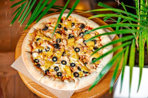 Delicious pizza with chicken meat pineapple corn and olives