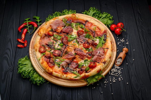 Delicious pizza with prosciutto and arugula